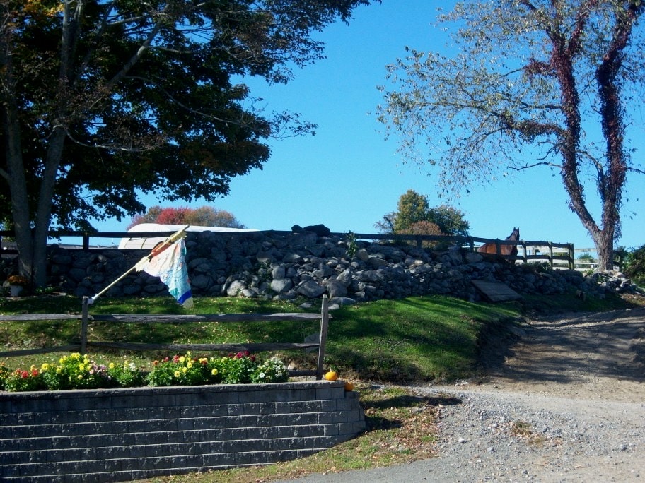 Farm entrance with stone wall and flowers